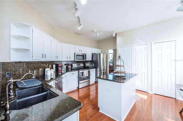 kitchen with sink, white cabinetry, tasteful backsplash, appliances with stainless steel finishes, and a kitchen island