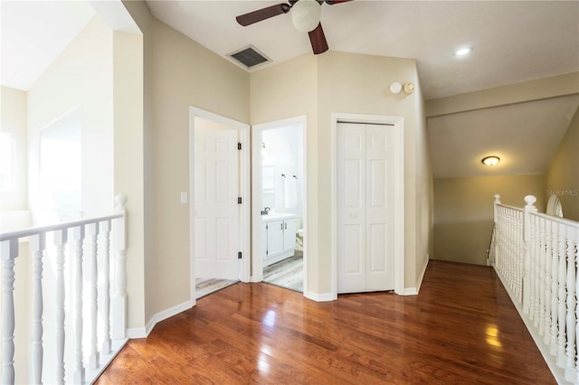 corridor featuring dark wood-type flooring and vaulted ceiling