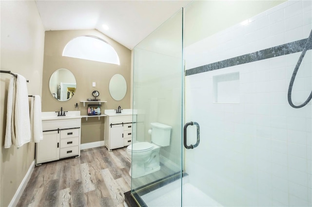 bathroom with a shower with door, vanity, wood-type flooring, vaulted ceiling, and toilet