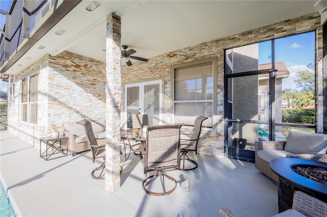 view of patio with ceiling fan and a fire pit