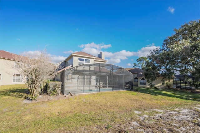 rear view of house featuring a swimming pool, a lawn, and glass enclosure