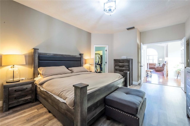 bedroom with a spacious closet, a closet, and light wood-type flooring