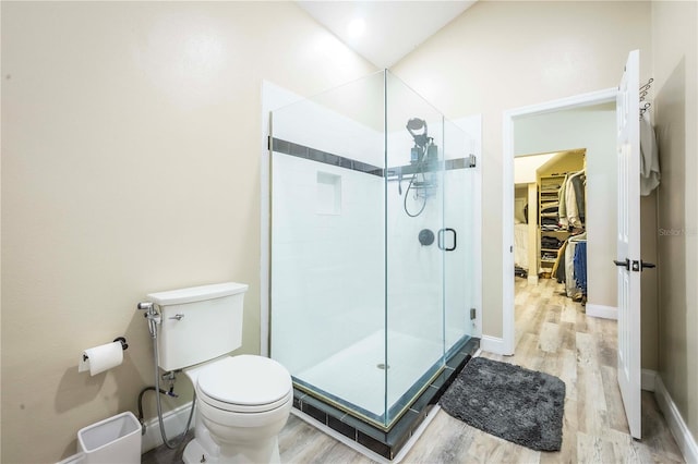 bathroom featuring an enclosed shower, wood-type flooring, toilet, and vaulted ceiling