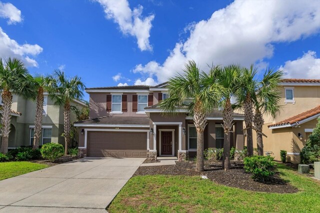 5295 Wildwood Way, Davenport, FL 33837 - view of front of house with stucco siding, concrete driveway, an attached garage, and stone siding