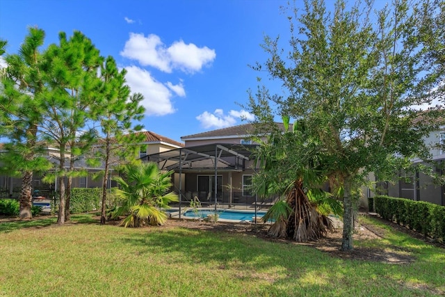 5295 Wildwood Way, Davenport, FL 33837 - rear view of house with a yard, an outdoor pool, a lanai, stucco siding, and a tiled roof