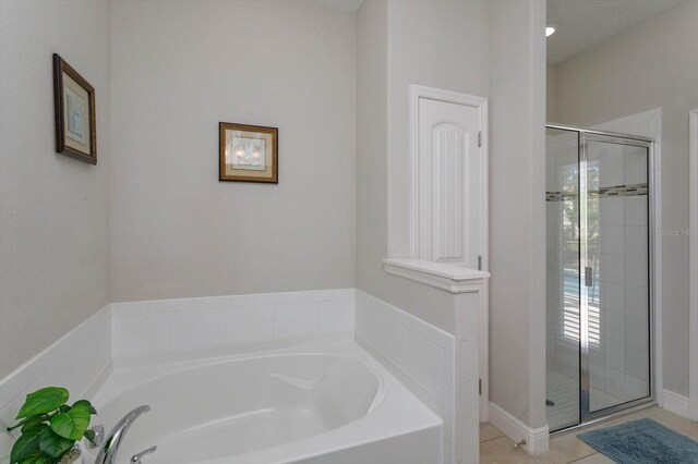 5295 Wildwood Way, Davenport, FL 33837 - bathroom featuring a shower stall, a garden tub, and tile patterned floors