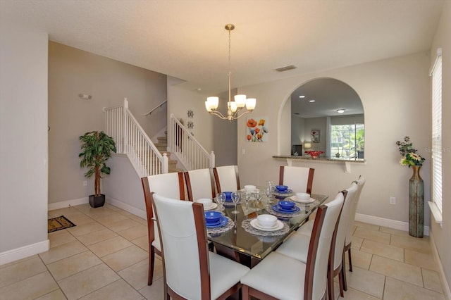 5295 Wildwood Way, Davenport, FL 33837 - dining room with a chandelier, stairs, light tile patterned floors, arched walkways, and baseboards
