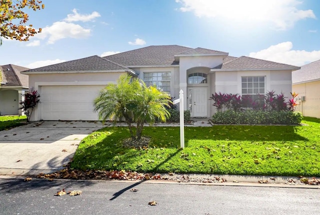 view of front of home with a garage and a front lawn