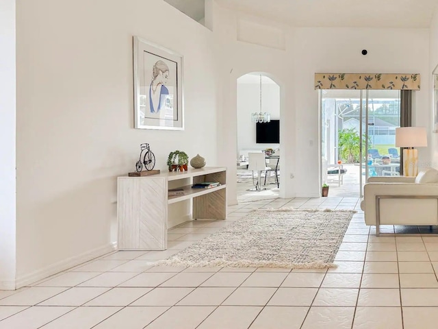 unfurnished living room with tile patterned flooring and a notable chandelier