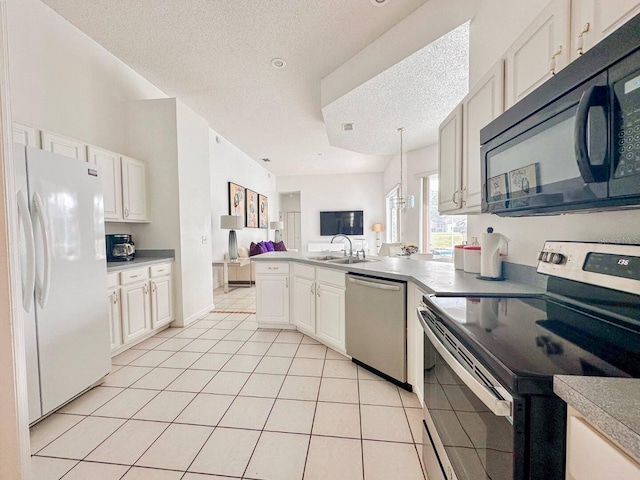 kitchen with sink, light tile patterned floors, a textured ceiling, appliances with stainless steel finishes, and kitchen peninsula