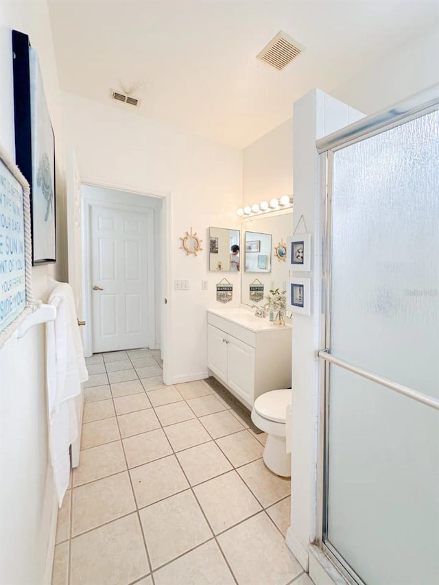 bathroom with tile patterned floors, vanity, an enclosed shower, and toilet