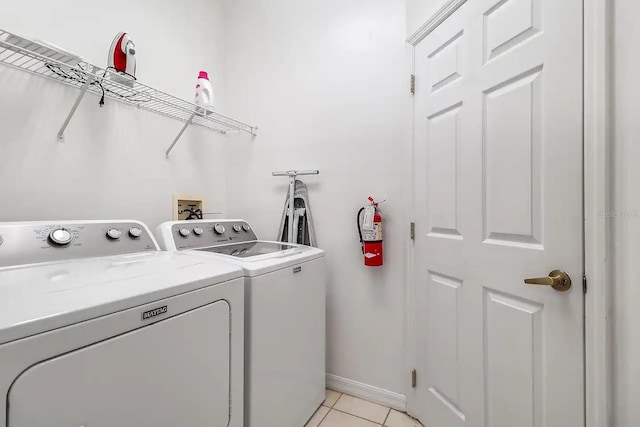 laundry room with light tile patterned floors and washing machine and clothes dryer