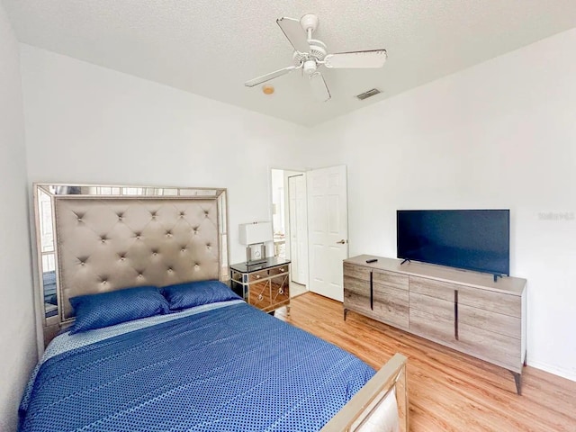 bedroom featuring ceiling fan, a textured ceiling, and hardwood / wood-style flooring