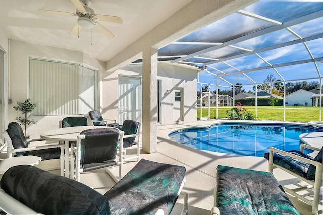 view of swimming pool with a patio, ceiling fan, a lanai, and a lawn