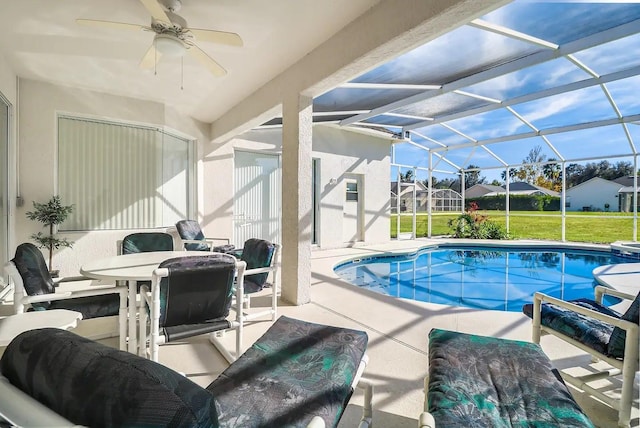 view of swimming pool with a lanai, ceiling fan, a yard, and a patio