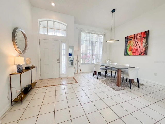 foyer entrance featuring light tile patterned floors, a high ceiling, and a wealth of natural light