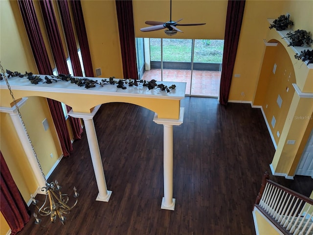 kitchen with a kitchen bar, dark hardwood / wood-style floors, ceiling fan, and decorative columns