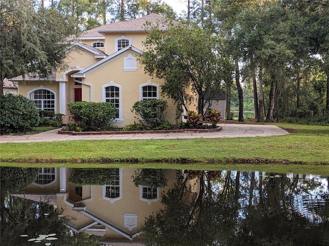 view of front of house featuring a front lawn and stucco siding