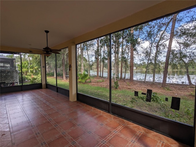 unfurnished sunroom featuring a water view and a ceiling fan