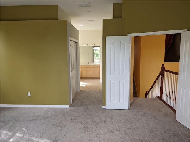 interior space featuring baseboards, visible vents, and light colored carpet