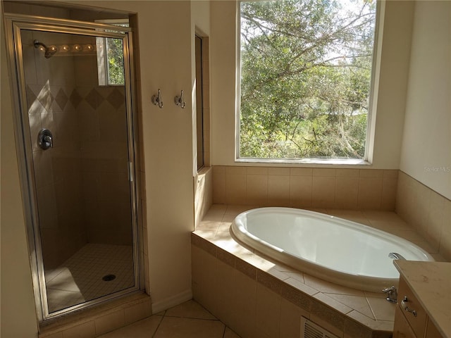 full bath featuring a stall shower, tile patterned flooring, a garden tub, and vanity