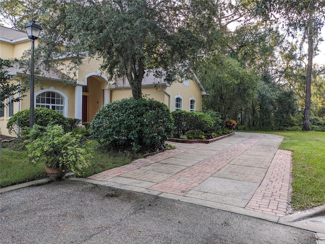 exterior space featuring a front lawn and stucco siding