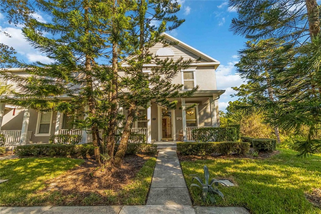 view of front of home featuring covered porch and a front lawn