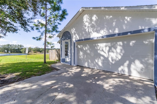 view of side of home featuring a lawn and a garage