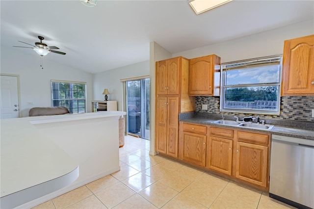 kitchen featuring vaulted ceiling, backsplash, ceiling fan, dishwasher, and a sink