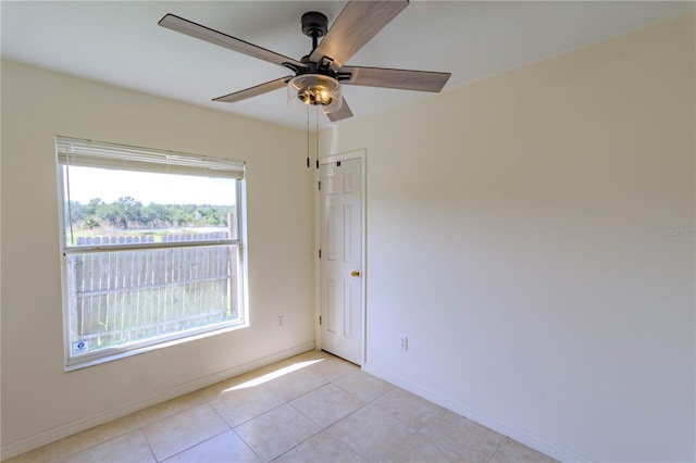 spare room with light tile patterned floors, ceiling fan, and baseboards
