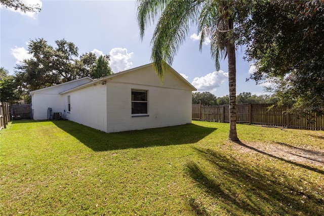 view of property exterior featuring a lawn, a fenced backyard, and central AC unit