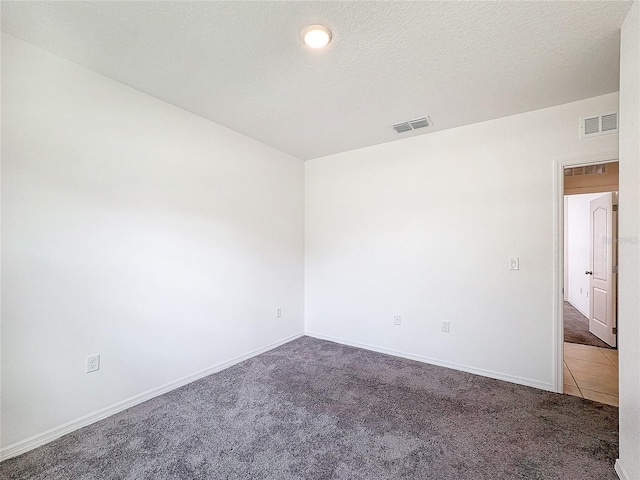 carpeted empty room with a textured ceiling