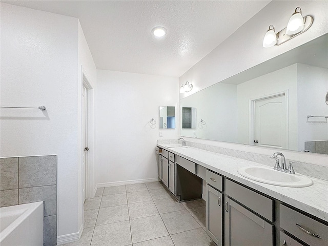 bathroom with vanity, tile patterned floors, a textured ceiling, and a washtub