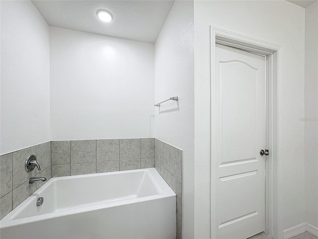 bathroom featuring a textured ceiling and a bathing tub