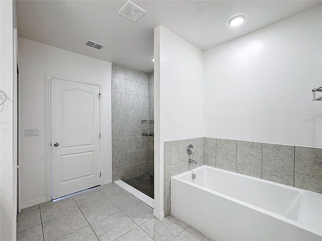 bathroom with tile patterned flooring, a textured ceiling, and separate shower and tub