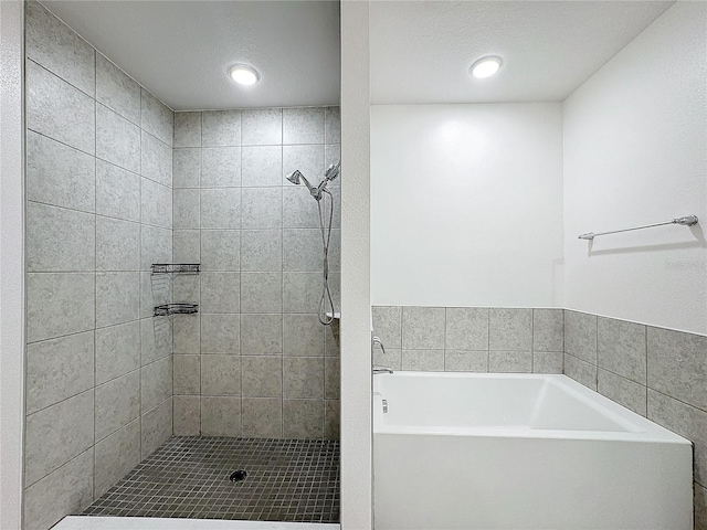 bathroom featuring independent shower and bath and a textured ceiling