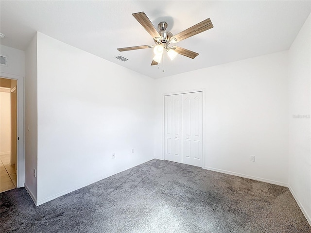 unfurnished bedroom with a closet, dark carpet, and ceiling fan