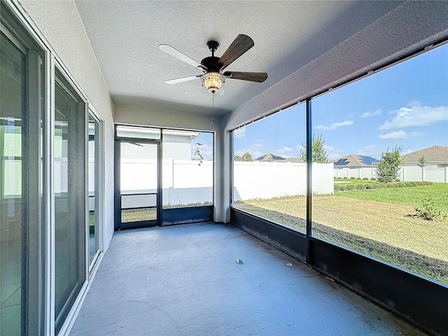 unfurnished sunroom with ceiling fan