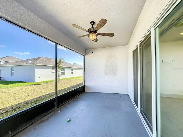 unfurnished sunroom featuring ceiling fan