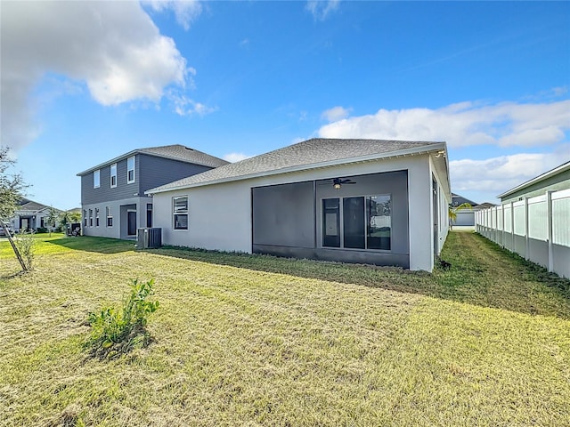 rear view of house with a lawn and ceiling fan