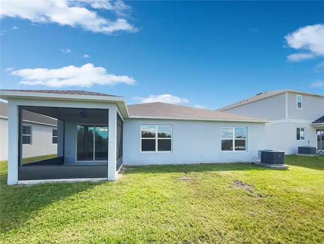 rear view of property featuring a yard, central AC unit, and ceiling fan