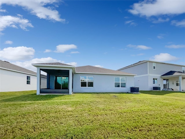 rear view of property with cooling unit and a lawn