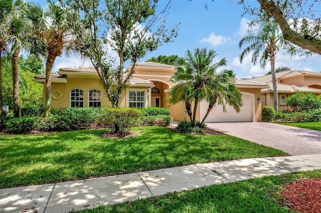 mediterranean / spanish home with a garage and a front lawn