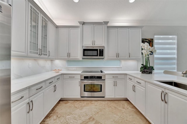 kitchen with sink, crown molding, white cabinetry, appliances with stainless steel finishes, and a textured ceiling