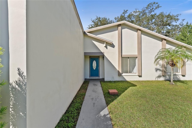 entrance to property with a lawn