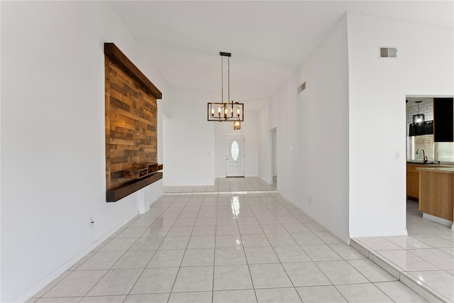 tiled entryway with a notable chandelier and sink