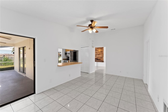 tiled empty room featuring ceiling fan