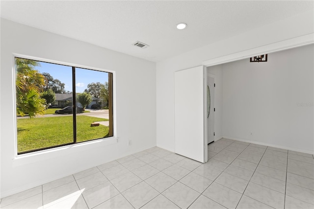 unfurnished room with a wealth of natural light and light tile patterned floors