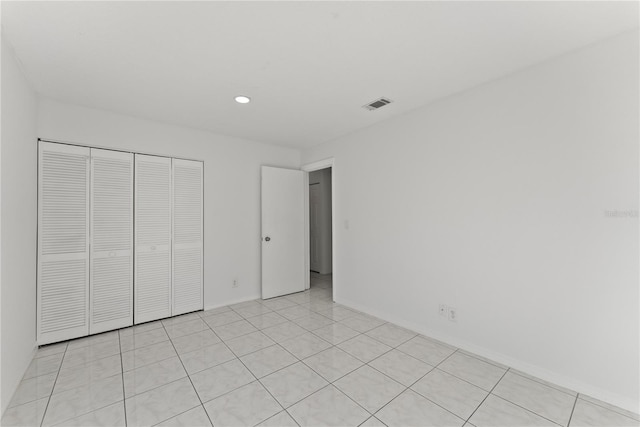 unfurnished bedroom featuring a closet and light tile patterned flooring