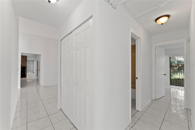 hallway featuring a textured ceiling and light tile patterned floors